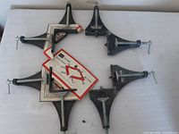Four Craftsman corner clamps arranged on a white surface with original tags attached, showing overall condition and design.