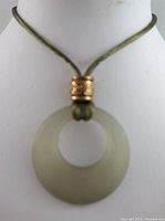 Front view of jade style circular pendant on olive green cord with decorative gold-tone bead.