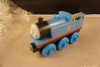 Blue wooden Thomas train engine viewed at an angle showing face and body