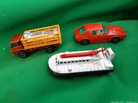 All three vehicles shown together on a green fabric background: hovercraft, cattle truck, and Renault 17 TL car