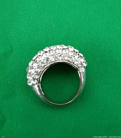 Clear image showing the full ring on green background with rhinestones arranged in a dense cluster.