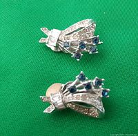 Pair of silver-tone clip-on earrings with clear and blue rhinestones.