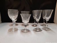 Front view of eight assorted vintage and antique liqueur glasses showing variety of shapes and patterns
