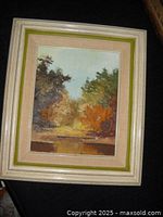 Photo showing entire framed impressionist landscape painting with autumn colors and green velveteen ribbing.