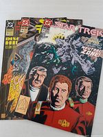 Three Star Trek comics from 1993 fanned out showing front covers with characters and Star Trek themes, each in clear protective plastic sleeves.