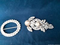 Photo of two vintage scarf clips on dark blue fabric background showing detail and size comparison