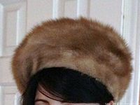 Side angled photo showing the voluminous, rounded shape of the mink fur cap and the soft texture of the fur.