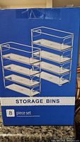 Box showing 8 piece set of small plastic storage bins with metal racks.