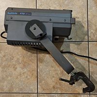 Image of vintage Buhl Buhlite F70 studio light showing the entire unit with clamp mount and arm attached, placed on tile floor.