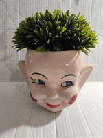 Front angled view showing the pixie elf ceramic container with plant inside.