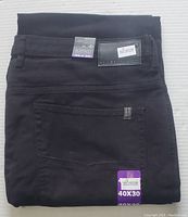 Folded black men's jeans showing label and size tag 40x30