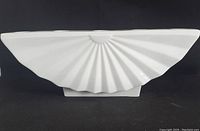 White fan-shaped fine bone china candleabra, smooth glossy finish, shown from front angle to display shape and texture.