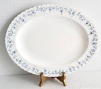 Full view of oval serving platter showing its shape, size, and floral border design with scalloped edges.