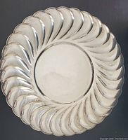 Full top view of vintage WM. Rogers silver-plated serving tray showing swirled edge design and surface wear.