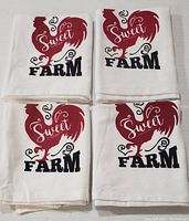 Four white cotton tea towels with the same red rooster and black "Sweet FARM" print stacked together on a white surface.