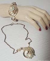 Necklace and bracelet displayed on mannequin hand, showing overall appearance and size.