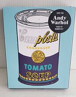 Box front showing Andy Warhol Soup Can paint by number kit packaging with Campbell's Tomato Soup can image on light blue background.