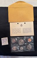 1970 Canadian Mint set sealed in plastic alongside Certificate of Authenticity and original Mint envelope, displayed flat on black and white background with lot number card.