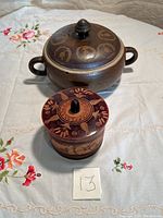 Both covered dishes shown on a floral tablecloth with lot number 13
