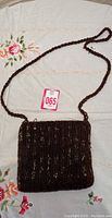 Full view of the vintage beaded purse showing the square shape, braided strap, and dark brown bead design.
