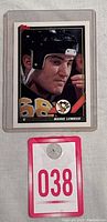 Close-up image of the Mario Lemieux hockey card in protective sleeve showing the player's face and uniform details.