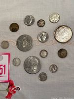 Group view of thirteen assorted coins on fabric background