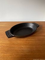 Top angled view of the oval cast iron casserole dish showing handle and interior surface.