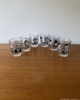 Front view of six shot glasses showing gangster mug shot images and details