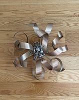 Top view showing curved metal arms and central light bulb sockets on wooden floor.