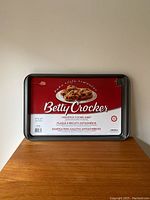 Front view of Betty Crocker nonstick cookie sheet in original packaging showing logo and baking image.