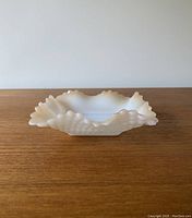 Front view of vintage square milk glass ruffled dish with hobnail texture, showing the bowl's shape and rim detailing.