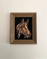 Framed horse head painting on black velvet against a plain wall showing full artwork and frame