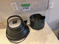 Instant Pot Air Fryer lid and air fryer insert basket on kitchen counter with seller's lot number visible. Shows both components of the lot.