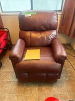 Front view of upright recliner showing leather upholstery and overall condition
