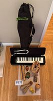 Photo of the musical instruments and keyboard with case arranged on wooden floor
