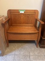 Front view of wooden storage bench labeled #6 on tile floor