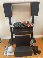 Overview of receiver, speakers on stands, center speaker, subwoofer, cables, remote and manual