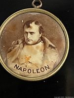 Front side with sepia portrait of Napoleon labeled 'NAPOLEON', housed in light copper-colored metal frame.
