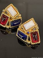 Front view showing three rectangular cabochons in red, white, and blue with gold-tone rope detailing.