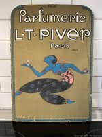 Full front view of vintage L.T. Piver Paris parfumerie poster on hard body backboard with art deco figure against burnished gold background.