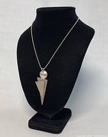 Front view of the necklace on a black display bust showing the pendant and chain.