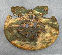 Close-up top view of jade pendant showing dragon carving and intricate openwork