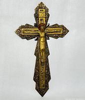 Front view of the antique metal crucifix showing Jesus on the cross with INRI plaque, decorative metal details, and gold-tone accents.
