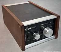 Angled front and top view showing black metal housing, wood side panels, front controls