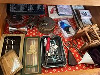Top view of drawer with varied barware items including wine openers, stirrers, coasters, and cocktail picks.
