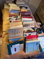 Photo showing a large assortment of books and journals arranged on a table, primarily on urban planning and design topics.