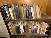 Two-shelf overview of vintage books showing mixed hard and soft covers