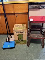 Photo showing two Bissell carpet sweepers side by side, Westmark coffee maker box, and vintage step stool with red seat.
