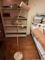 Full view of the vintage floor lamp showing adjustable arm, metal shade, round base, and general appearance in room setting.