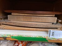 Stack of wooden cutting boards showing different sizes and thicknesses, some with handles